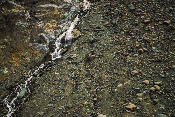 texture naturelle détaillée de pente de pierrailles. jet d’eau de montagne descend à flanc de montagne. petite chute d’eau sur la roche. paysages insolites de la nature majestueuse. - waterfall rock mountain bright photos et images de collection