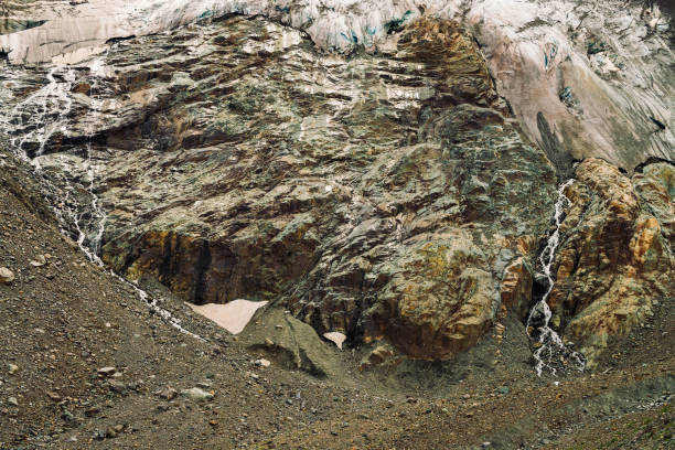 détaillée de texture naturelle du rocher géant de forme fantastique recouvert de neige et de glace dans les hautes terres. petites cascades et ruisseaux coule vers le bas de la montagne. paysage de montagne fantastique de la nature majestueuse. - waterfall rock mountain bright photos et images de collection