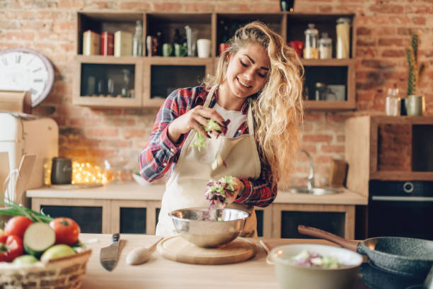 istock Female cook in apron prepares fresh salad 1026488384
