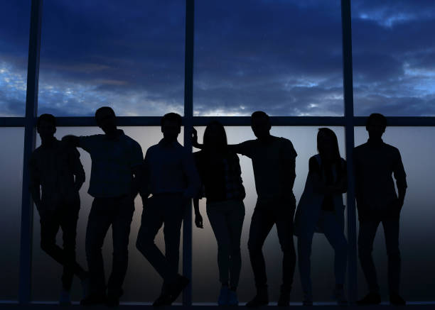 istock business team standing near the window, evening, dark 1026498648