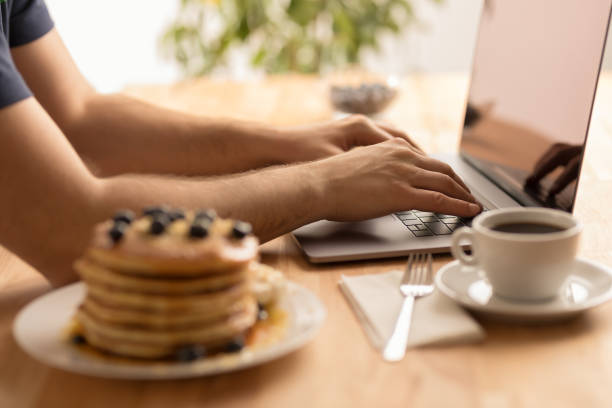 Young male hands working on laptop at home