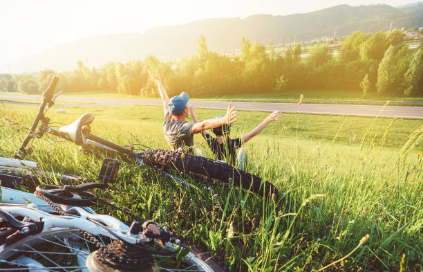 istock Father and son rest together in green grass when have bicycle walk 1026523508