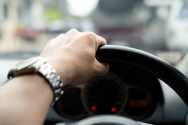 istock Hand a Man Driving car on the road in traffic jam 1026523698