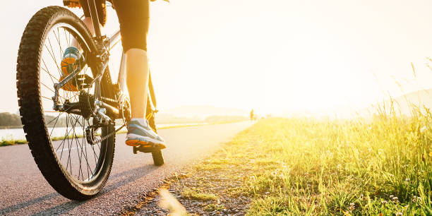 kobieta stóp na pedał bycikle w świetle zachodu słońca - bicycle pedal zdjęcia i obrazy z banku zdjęć