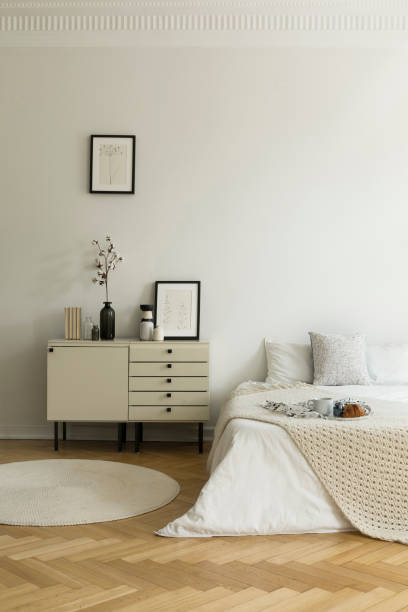 istock Monochromatic, white bedroom interior with a bed and a nightstand. Breakfast served on the bed. Real photo. 1026526644