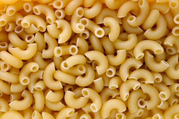 Dry small pasta in the form of short half round  tubes stock photo