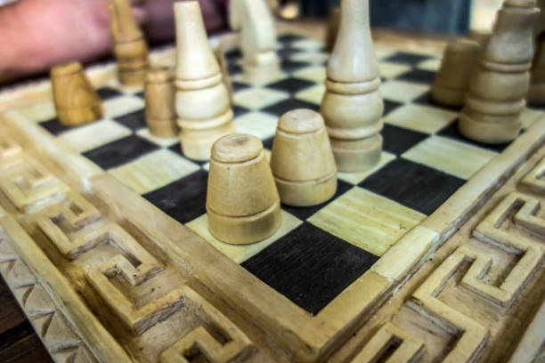 Wooden vintage chess pieces placed on a chessboard outdoors close-up