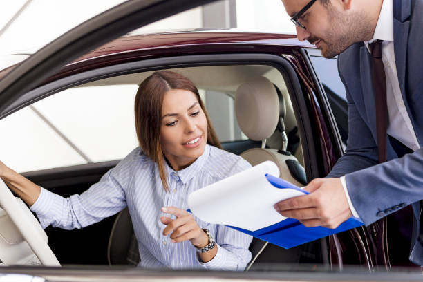 istock Car salesman signing a contract with customer 1026550552