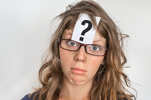 Woman is looking for a solution to the problem with question mark on paper over her forehead
