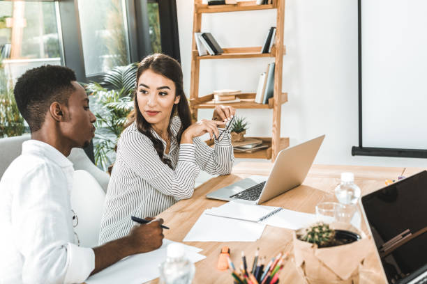 istock portrait of multiethnic business colleagues discussing work while sitting at workplace in office 1026577206