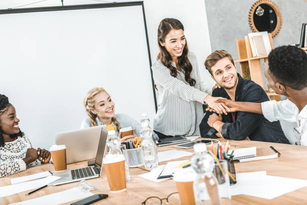 istock smiling multiethnic business partners shaking hands during conference with multicultural colleagues in office 1026577348