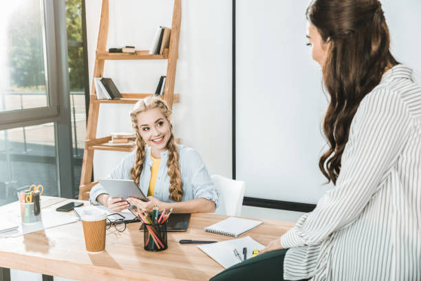 istock young multicultural businesswomen having conversation at workplace in office 1026579852