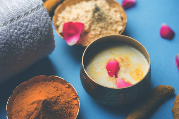 istock Ayurvedic face pack/mask using Gram Flour/besan, Haldi & milk ubtan placed in brass bowls with rose petals, scrub  and white napkin. selective focus 1026580084