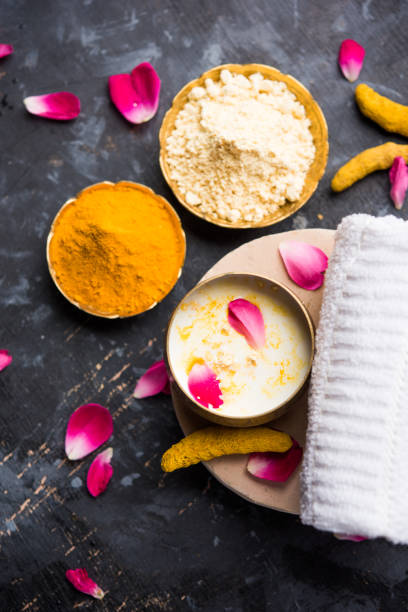 istock Ayurvedic face pack/mask using Gram Flour/besan, Haldi & milk ubtan placed in brass bowls with rose petals, scrub  and white napkin. selective focus 1026581164