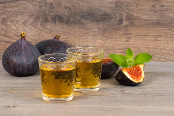 figs liqueur and fresh fruits and mint on rustic table