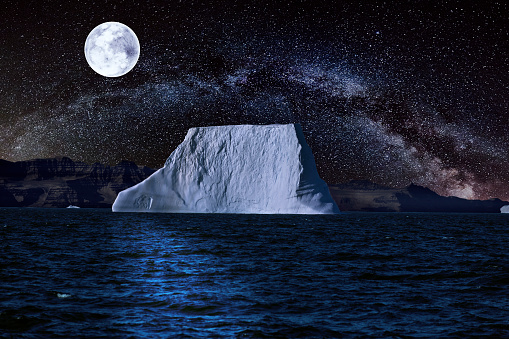 iceberg with starry night and a full moon.