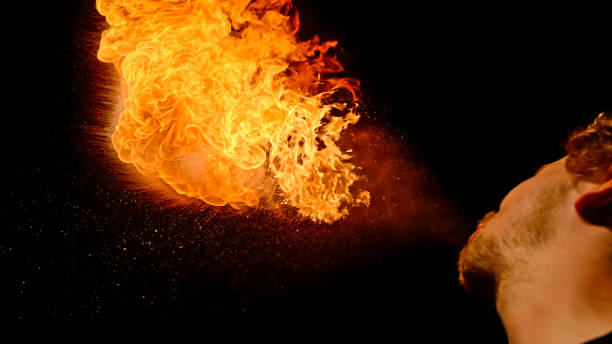 istock Fire breather blowing fire ball from her mouth 1026587828
