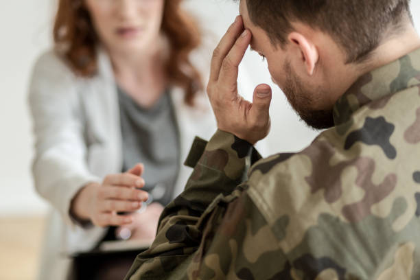 Depressed soldier with suicidal thoughts wearing green uniform during therapy with psychiatrist Depressed soldier with suicidal thoughts wearing green uniform during therapy with psychiatrist post traumatic stress disorder photos stock pictures, royalty-free photos & images
