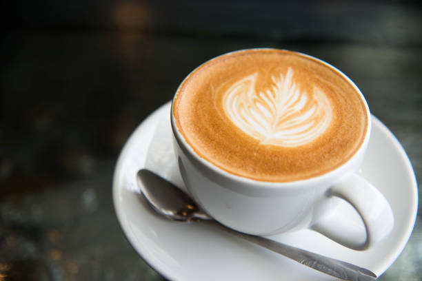 istock White cup of coffee latte art leave from fresh milk on the table. 1026597930