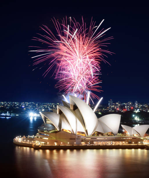 increíble volea de rosa fuegos artificiales estallando por encima de la casa de ópera de sydney - sydney opera house sydney harbor opera house bright fotografías e imágenes de stock