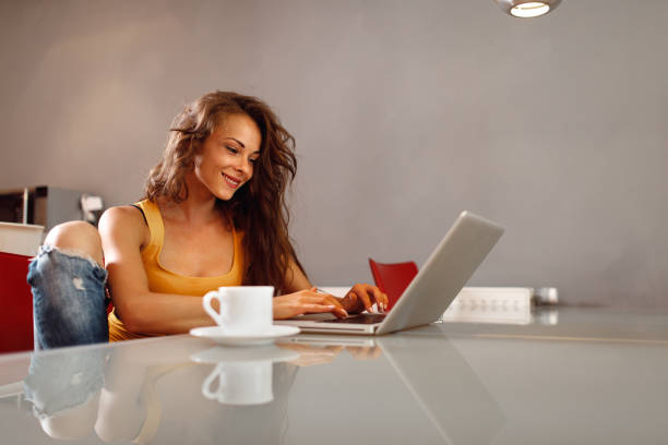 istock Young woman typing on a laptop at home at the table 1026603982