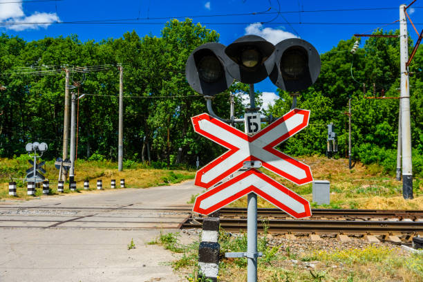 railroad crossing sign and semaphore in front of the railroad crossing - railroad crossing railway signal gate nobody imagens e fotografias de stock