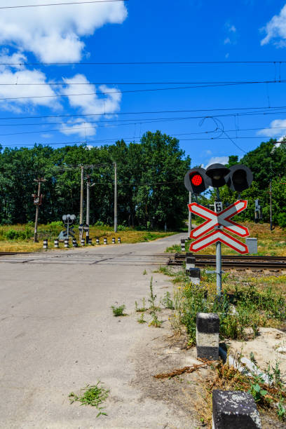 railroad crossing sign and blinking semaphore in front of the railroad crossing - railroad crossing railway signal gate nobody imagens e fotografias de stock