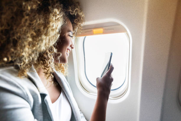 istock Confident young woman uses smartphone during flight 1026611468