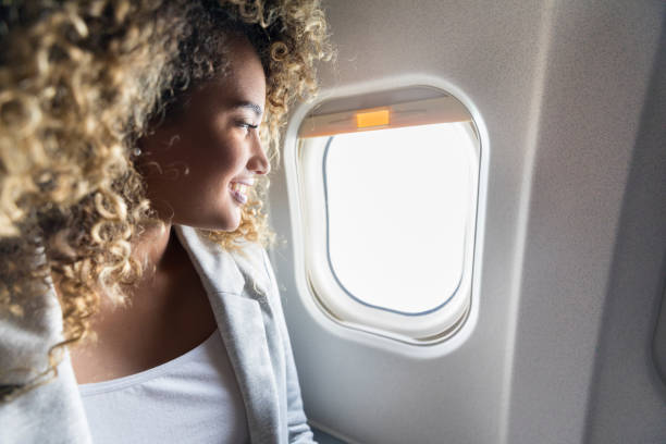 istock Woman looks through window on airplane 1026611482