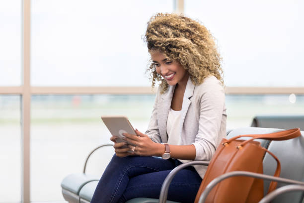 istock Woman uses digital tablet while waiting for flight 1026611528