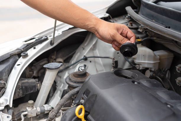 istock Man hand technician checking or fixing the engine of a modern car. Mechanic performing maintenance and car self fixing or maintenance. 1026611590