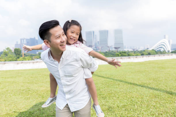 istock Little girl pretends to fly while playing in park 1026611612