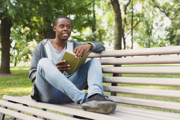 istock African-american student reading a book outdoors 1026616780