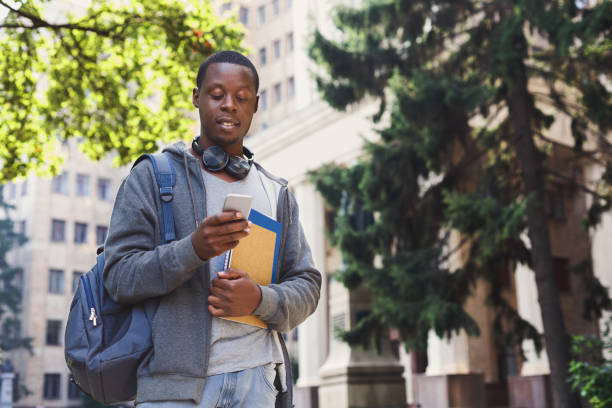 istock Happy african-american student texting in university campus 1026617434