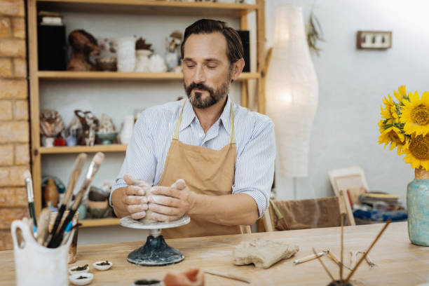 istock Dark-haired ceramist feeling satisfied during the process of work 1026628388