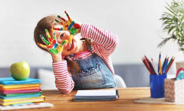 garota engraçada criança desenha rindo mostra mãos sujas com pintura - escola fundamental educação fotos - fotografias e filmes do acervo