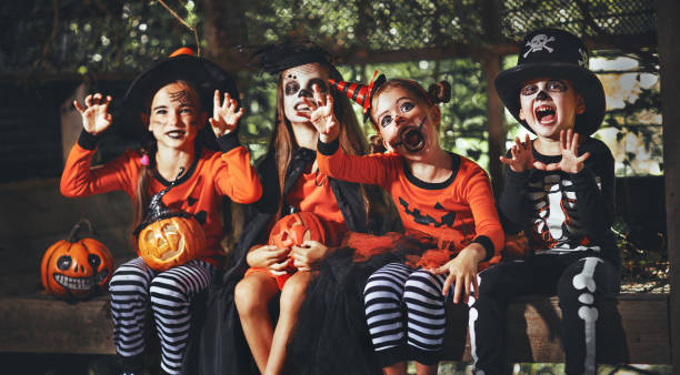 ¡feliz halloween! un grupo de niños vestidos con trajes y con calabazas en bosque - witchs hat costume witch holidays and celebrations fotografías e imágenes de stock