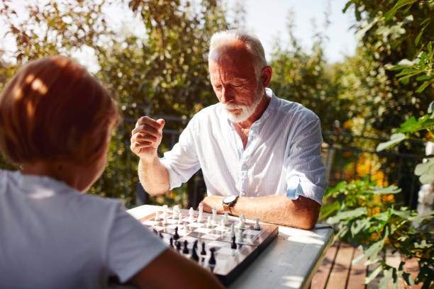 Playing Chess grandfather grandson 8 years old boy playing chess with his grandfather. senior chess stock pictures, royalty-free photos & images