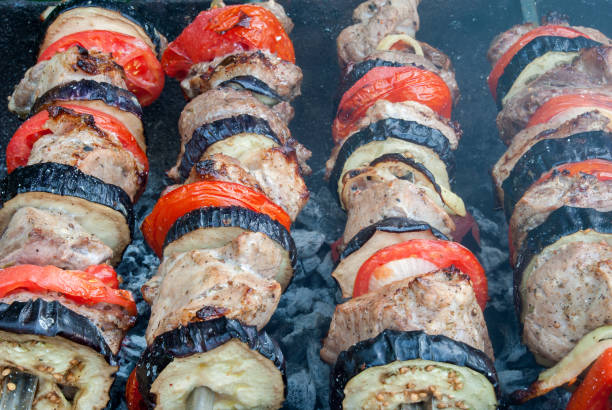сочные кусочки мяса с соусом готовят на огне шашлык - chicken brochette стоковые фото и изображения