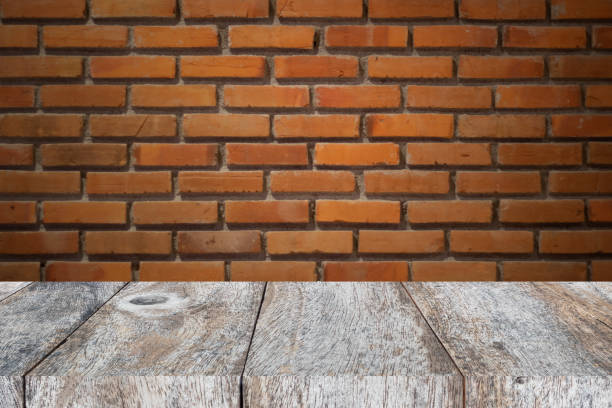 istock wood table and brick wall for display product 1026652812