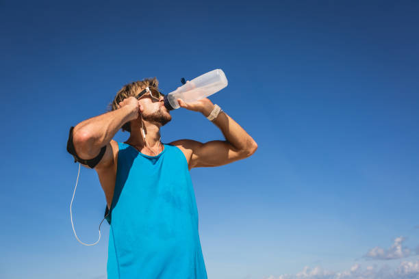 istock athletic man drinking water from sports bottle 1026653152