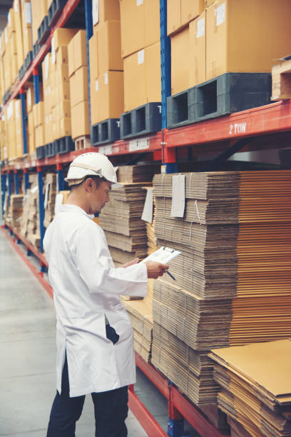 istock Young man white uniform checking stock at store factory 1026674556