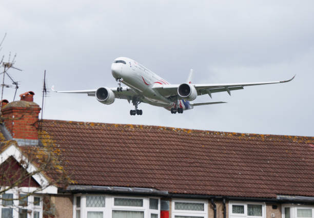 London, United Kingdom - April 3, 2108:  Malaysia Airlines Airbus A350-941 with identification 9M-MAC landing at Heathrow airport. This aircraft feature special Malaysia Negaraku Livery. Clouded sky in background. Image is showing landing path of heavy aircraft over the houses near airport.