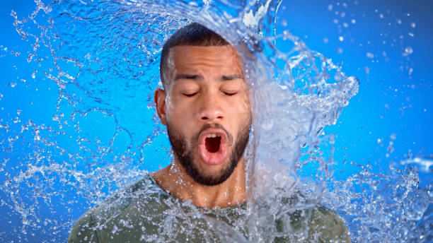 uomo spruzzato d'acqua - splashing color image front view head and shoulders foto e immagini stock