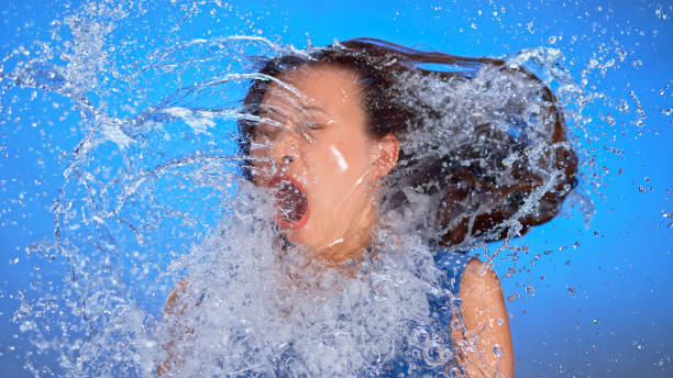 donna spruzzata d'acqua - splashing color image front view head and shoulders foto e immagini stock