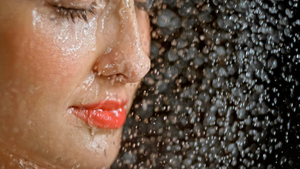 istock Close-up of woman being splashed with water 1026679692