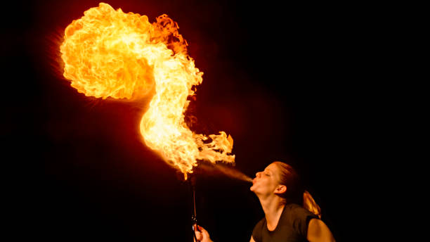 istock Fire breather blowing fire ball from her mouth 1026679698