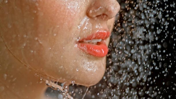 istock Close-up of woman being splashed with water 1026679706