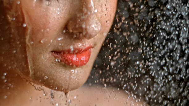 istock Close-up of woman being splashed with water 1026679708