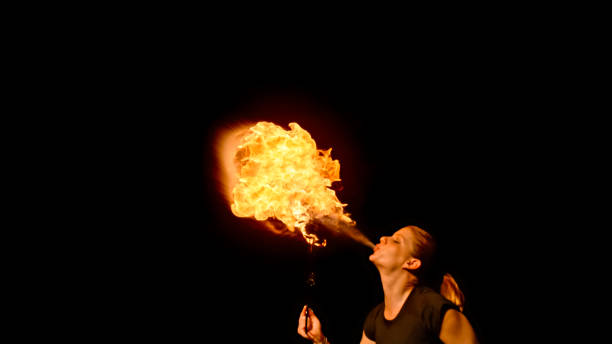istock Fire breather blowing fire ball from her mouth 1026679716